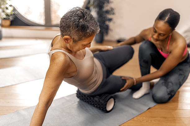 istock Senior woman streching with assistance from a personal trainer 2250449551