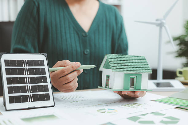 istock Eco-friendly housing model with solar panel and business charts on desk, symbolizing green building, renewable energy, sustainable architecture and environmental innovation concept. 2250458662