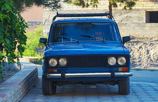 There is an old blue car on the street