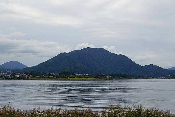 istock Quiet lake with dark mountain ridge under overcast sky 2250459704