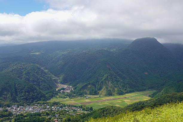 istock Steep grassy slope above distant coastal town and bay 2250460147