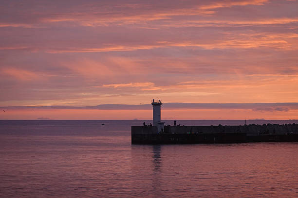 istock Intense red sunset over harbor entrance and dark silhouettes 2250460697