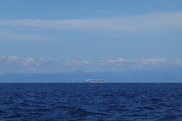 istock Open blue sea stretching toward distant cloud band horizon 2250461154