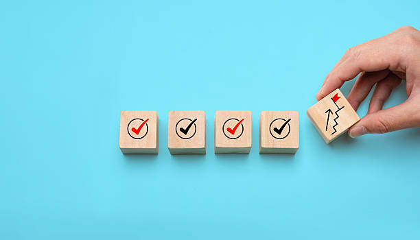 istock Success building concept with hand stacking wooden blocks step by step, showing checkmarks and progress icons, representing achievement, planning, strategy, and long-term development. 2250461682