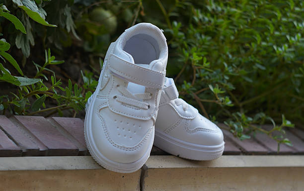 White sneakers stand on the ground in nature