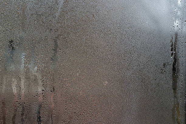 istock Abstract wet window texture. Chaotic of droplets fogged glass, creating organic patterns. condensation on window. wet glass abstract background for design. 2250466455