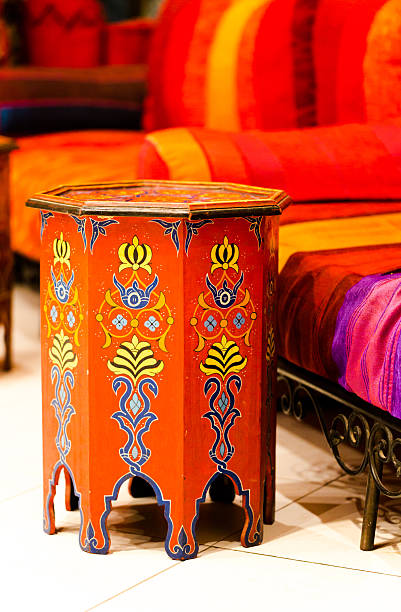 Moroccan vibrant ornate decorative stool with floral pattern in bright orange and blue hues for home decor