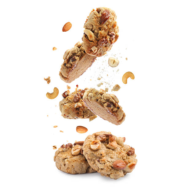 Yummy nut cookies falling on white background