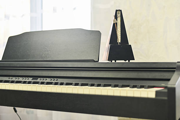 Mechanical metronome on modern electronic piano, symbolizing precision and rhythm in music. Precision is crucial for mastering musical timing and performance.