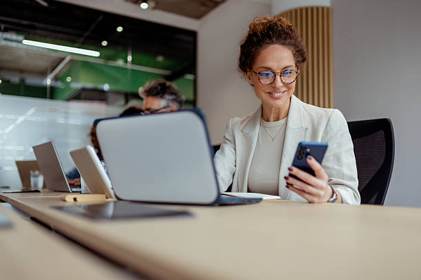 istock Confident Mature Businesswoman Smiling While Using Smartphone in Office Meeting 2250472269