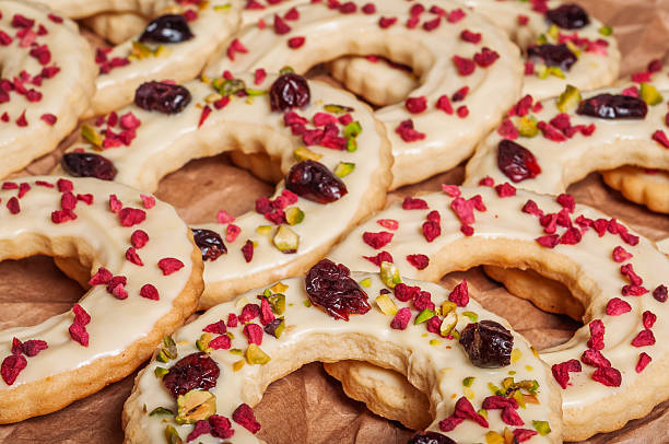 Delicious crescent cookies with white icing, cranberries, and pistachios