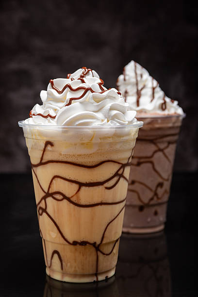 istock Vanilla milkshake with chocolate syrup in clear glass on dark background. 2250482540