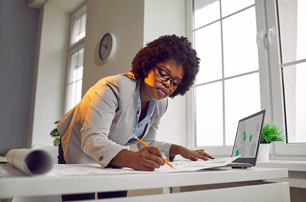 istock African American woman architect drawing blueprints in modern office 2250483094