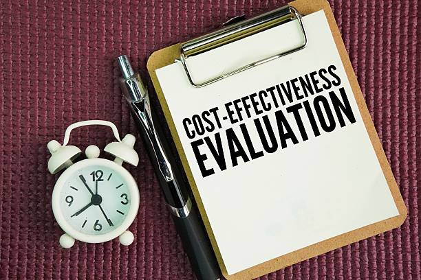 istock A whiteboard, an alarm clock and a pen with the words Cost-Effectiveness Evaluation. 2250484074