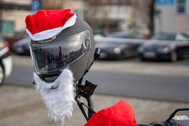 Motorcycle helmet decorated with Santa hat and fake beard used as a humorous accessory during a festive holiday street parade