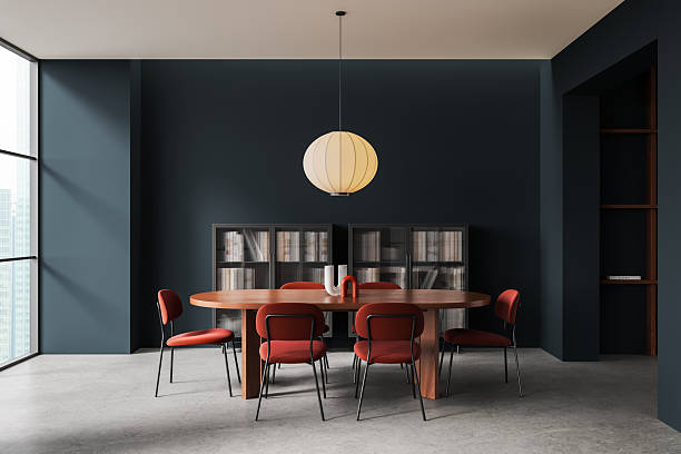 istock Modern dining room interior with wooden table, red chairs, large pendant light, and dark blue walls in minimalist design aesthetic. 3D Rendering 2250493911