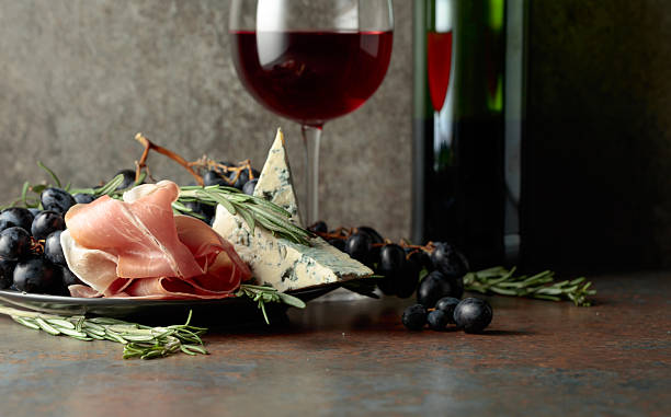 istock Red wine with grapes, rosemary, prosciutto, and blue cheese. 2250498070