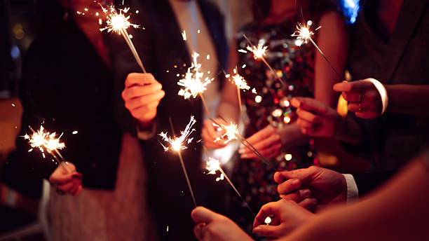 istock A happy group is having fun at a bar, drinking drinks, and lighting sparklers in a cozy space. 2250498148