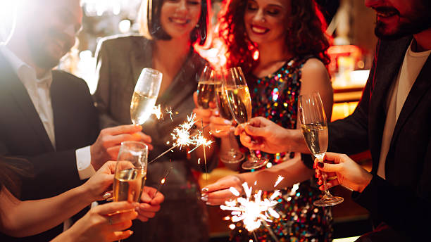 istock A happy group is having fun at a bar, drinking drinks, and lighting sparklers in a cozy space. 2250498188