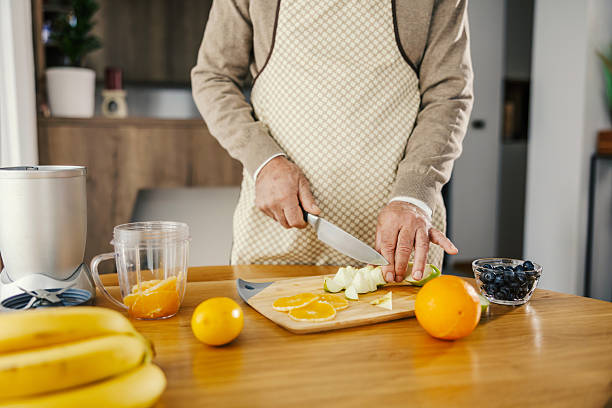 istock Senior man cutting fresh fruit for healthy smoothie 2250498299
