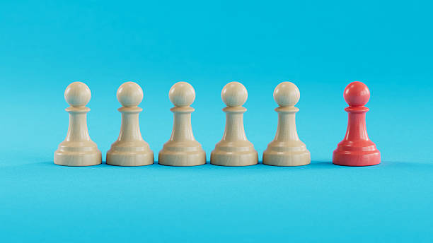 istock Solo Red Pawn Apart From Five Beige Pawns: Symbolizing Uniqueness 2250498605