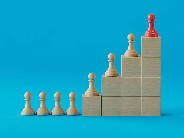 istock Red Pawn Tops Stepped Tower: Symbolizing Leadership and Ranked Success 2250498643