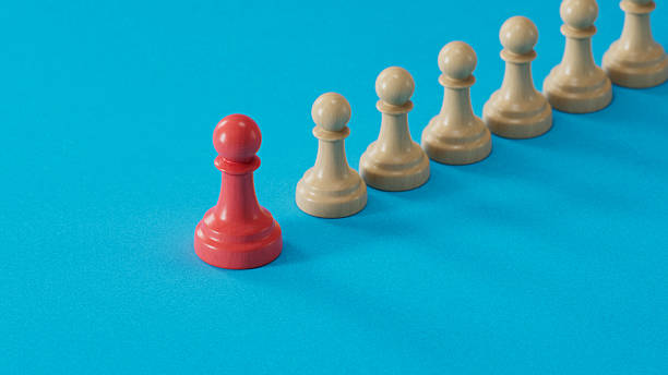 istock Solo Red Pawn Apart From Beige Pawns: Symbolizing Uniqueness 2250498660