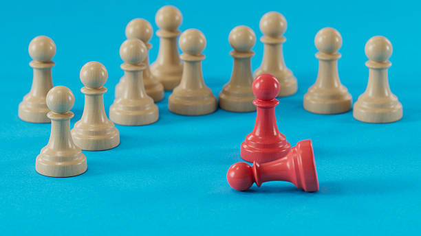 istock Standing & Fallen Red Pawns: Duality Among Beige Crowd 2250498663