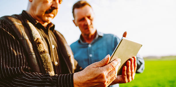 istock Farmers in a field working on a digital tablet. Close-up. 2250498678