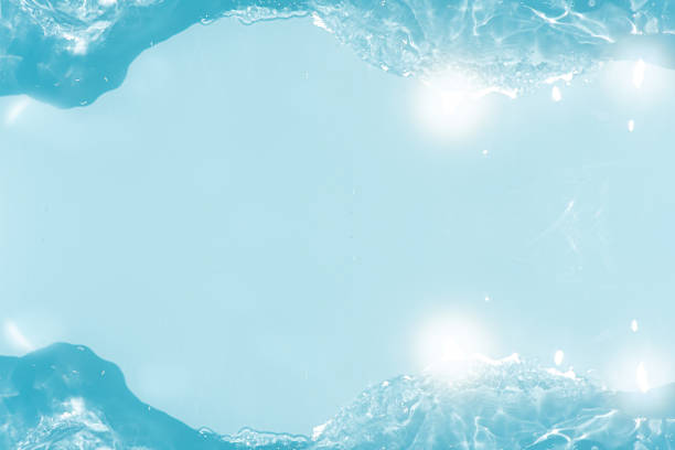 Blue water with ripples on the surface. Defocus blurred transparent blue colored clear calm water surface texture with splashes and bubbles. Water waves with shining pattern texture background.