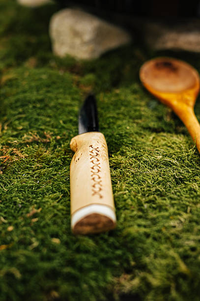 Handcrafted Knife on Moss in Outdoor Cooking Setup