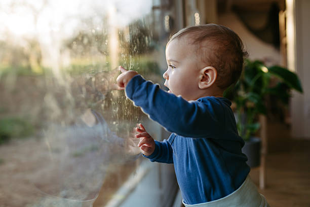 istock A little toddler is looking out the window. 2250503428