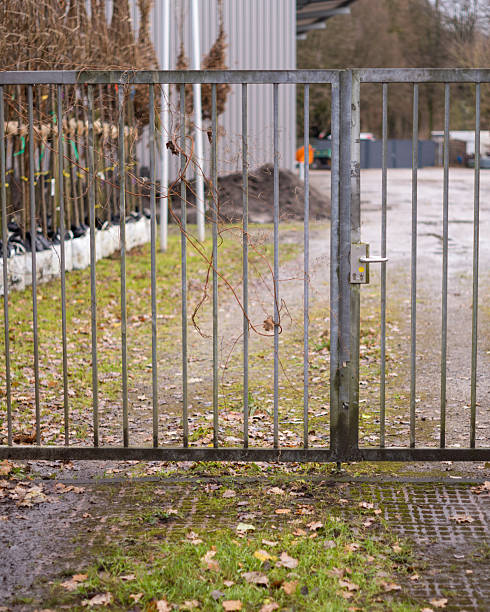 istock Closed metal gate protecting industrial area with saplings 2250503633