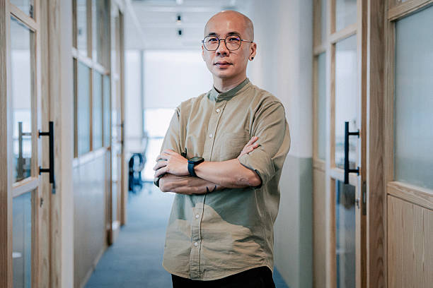 istock Confident Asian professional standing in a modern office hallway 2250504751