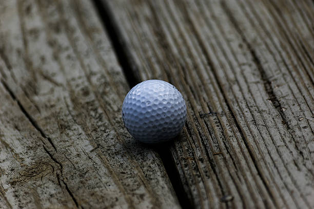 istock Golf Ball Resting on Grooved Weathered Wood 2250506768