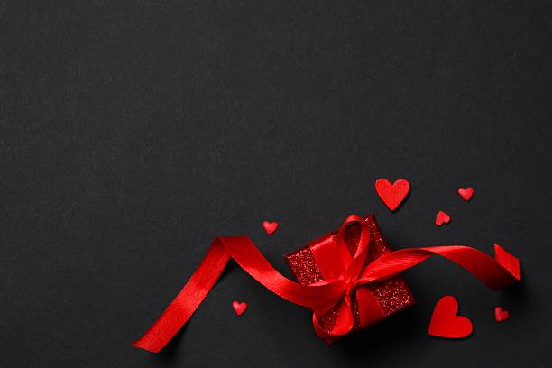 istock Gift box with red hearts on black background 2250512159