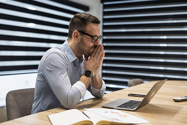 istock Focused professional working intently on laptop in a modern office space during a team meeting 2250513950