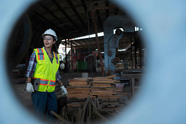 istock Woman Worker Inspecting Large Industrial Machine in Wood Processing Facility 2250517474