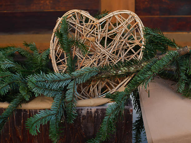 istock Rustic Wicker Heart Surrounded by Evergreen Branches as Natural Christmas Decoration Placed Outdoors on Wooden Surface Creating Warm Seasonal Atmosphere 2250521857