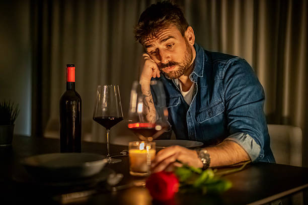 istock Man reflecting on love with wine and a rose during a quiet evening at home 2250522657