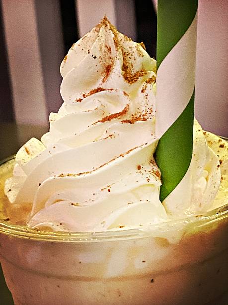 Whipped Cream topped Milkshake with a Green Striped Straw