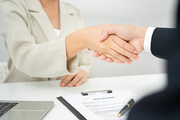 istock Executives accept job application and shake hand, documents and job applicants resume to match the position. company publishes vacancies online to find human. Human resource, interview, letters. 2250523304