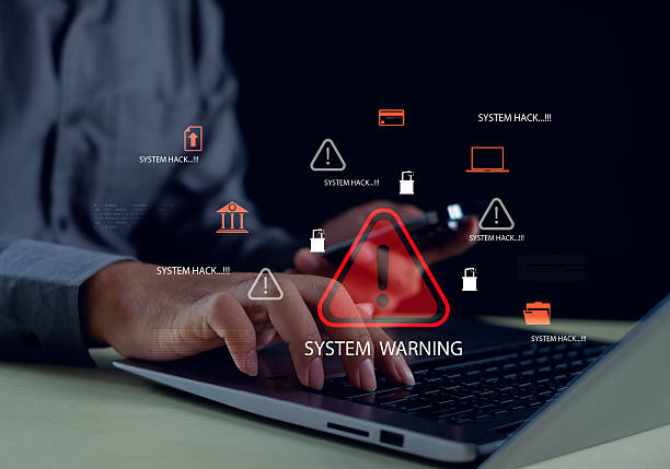 istock business professional working on a laptop with digital system warning icons, representing cyber threats, data breach risks, hacking alerts, and the importance of strong cybersecurity protection. 2250525900