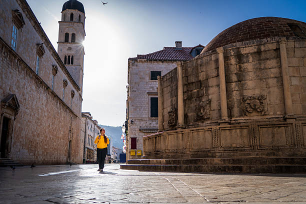 Tourist strolling through the streets of Dubrovnik, Croatia. Young woman walking through the streets of Dubrovnik in the morning. Tourist on vacation in Dubrovnik, Croatia
