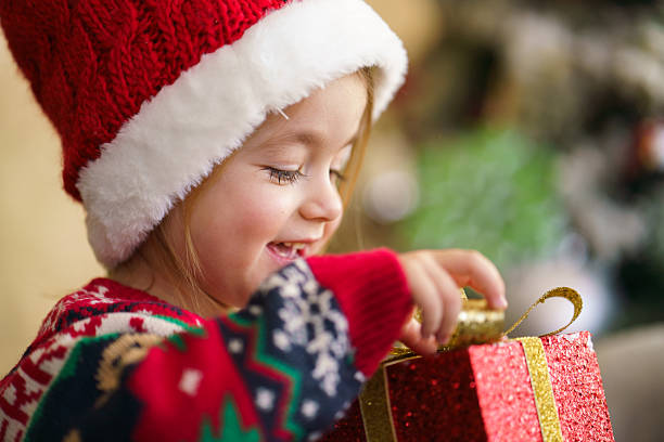 istock Little girl opening christmas present with joy. 2250529578