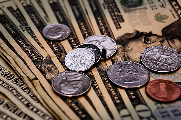 istock Close-Up US Currency Scattered On Surface Including Benjamin Franklin Bills Coins 2250530565