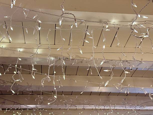 istock Cozy rustic living room decorated for Christmas with warm string lights, a beautifully adorned ceiling. 2250530836