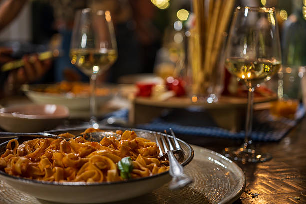 istock Italian Pasta Dish Served with White Wine at a Cozy Dinner Gathering 2250530892
