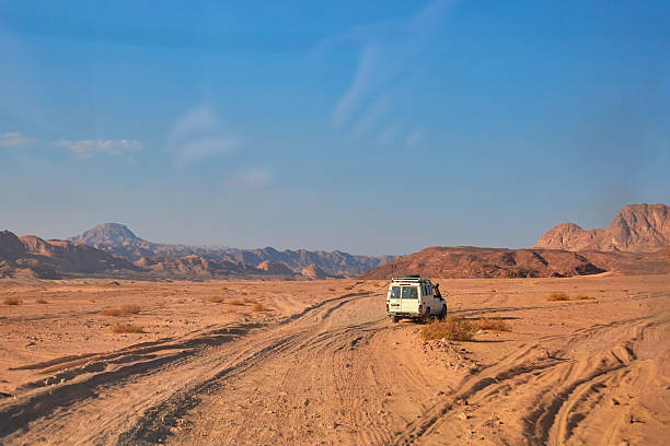 istock Off-road vehicle navigating sandy terrain in vast desert landscape 2250532178
