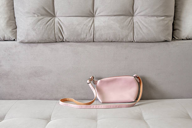womens pink handbag with strap on sofa
